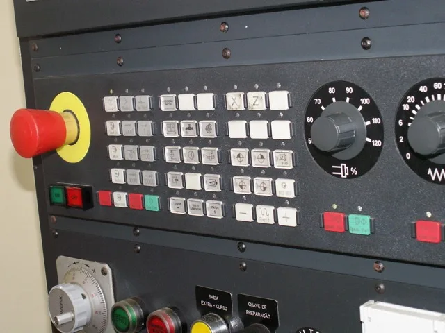CNC gépkezelő vezérlőpultja vészleállító gombbal és forgókapcsolókkal